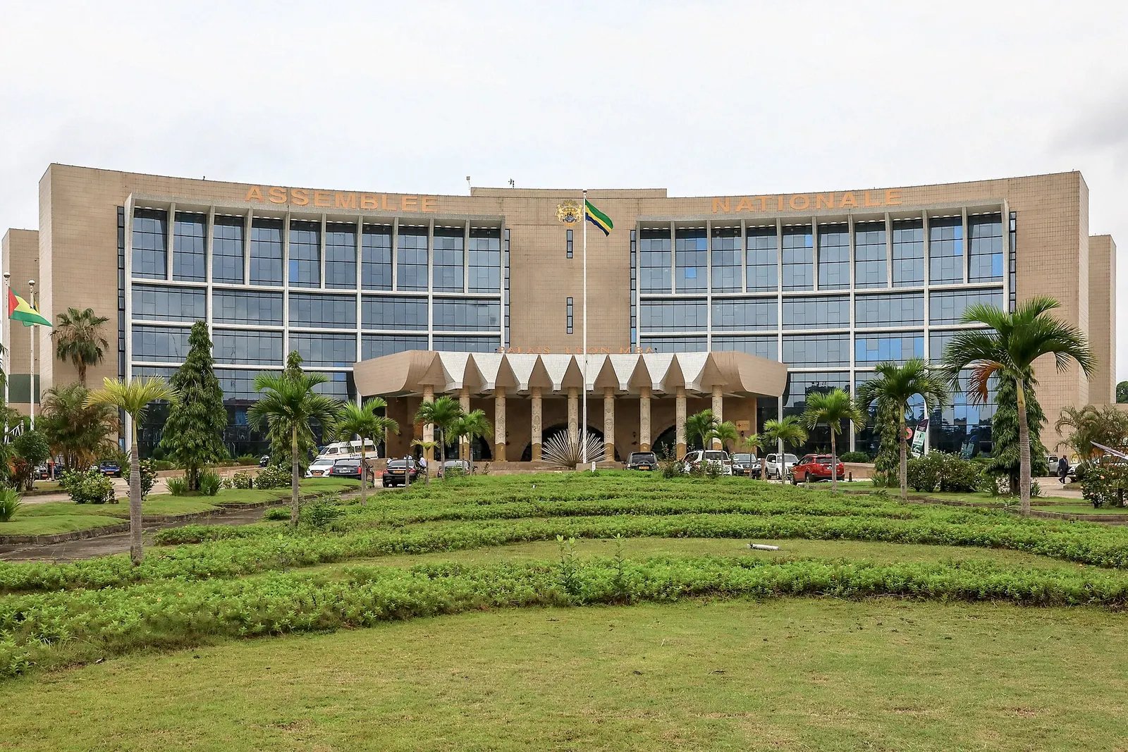 Façade du palais Léon Mba à Libreville, précédée de pelouses et de palmiers