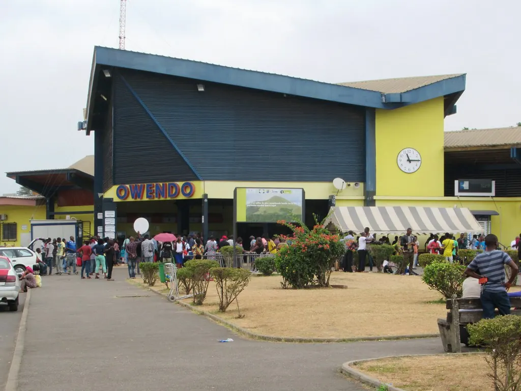 Façade de la gare ferroviaire d'Owendo avec des voyageurs sur le parvis