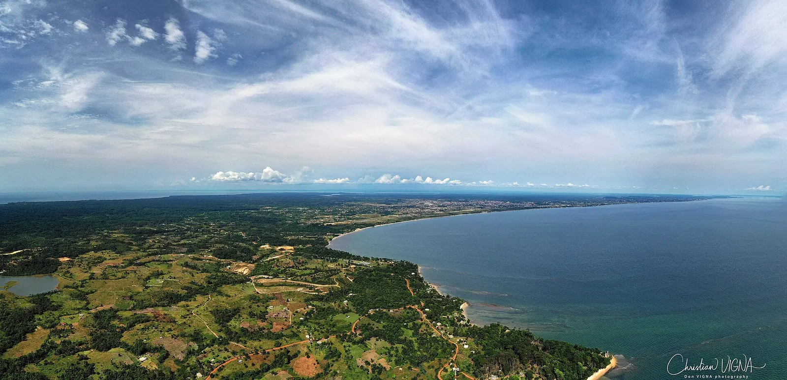 Vue aérienne de la côte boisée de l'estuaire avec la ville de Libreville à l'horizon