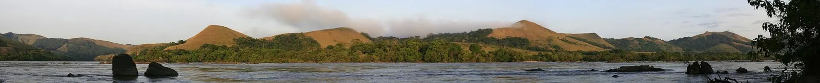 Wide panoramic view of a river winding through the forest of Lopé National Park
