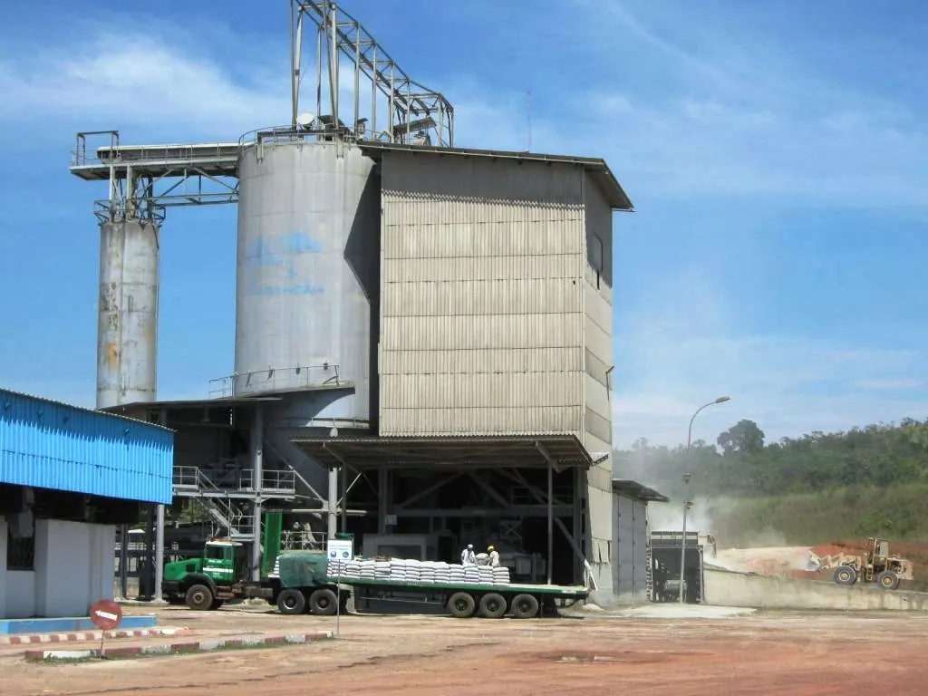 Silos et bâtiments de la cimenterie de Ntoum avec un camion au premier plan