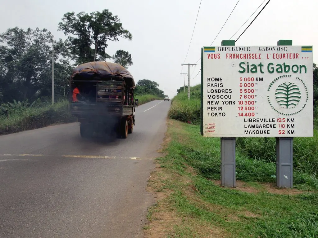 A truck on the road between Libreville and Lambaréné near a sign marking the equator