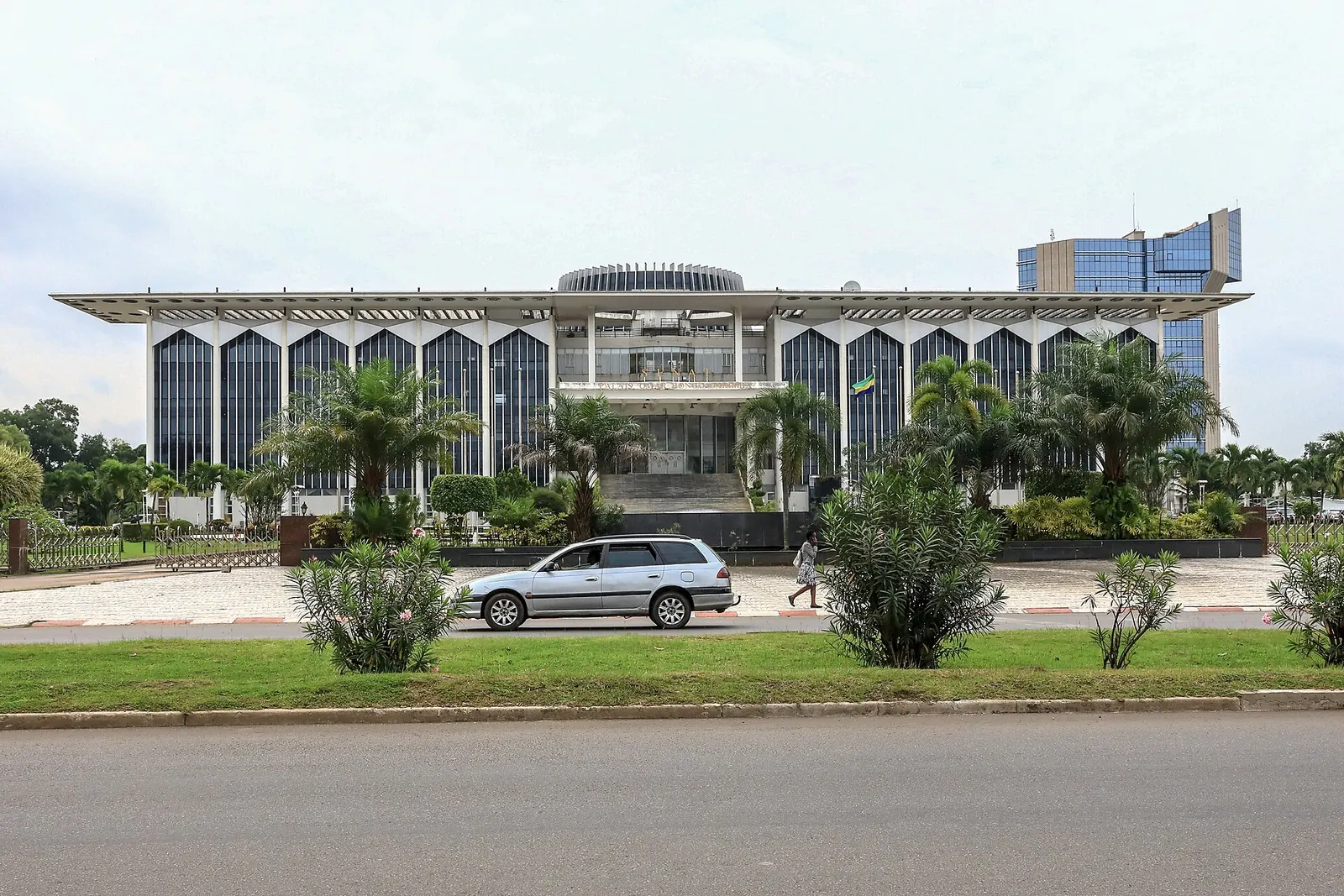 Bâtiment à colonnades du Sénat à Libreville derrière une avenue bordée de verdure