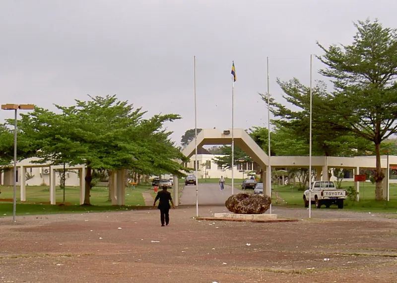 Entrance gate of the university in Franceville with a large stone in the middle of a roundabout
